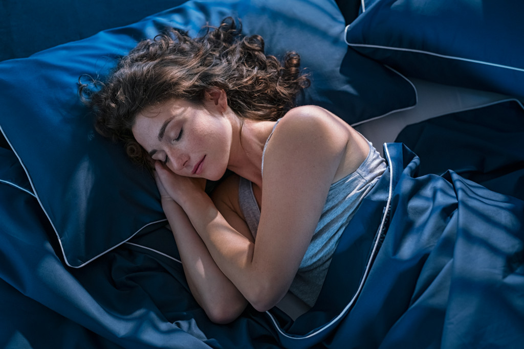 woman asleep in blue sheets